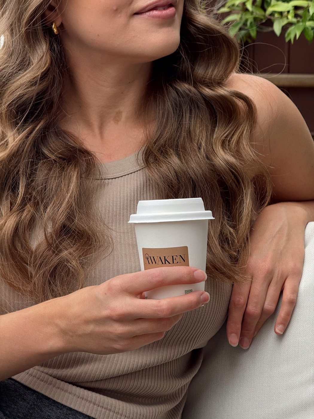 Woman holding a branded takeaway coffee cup